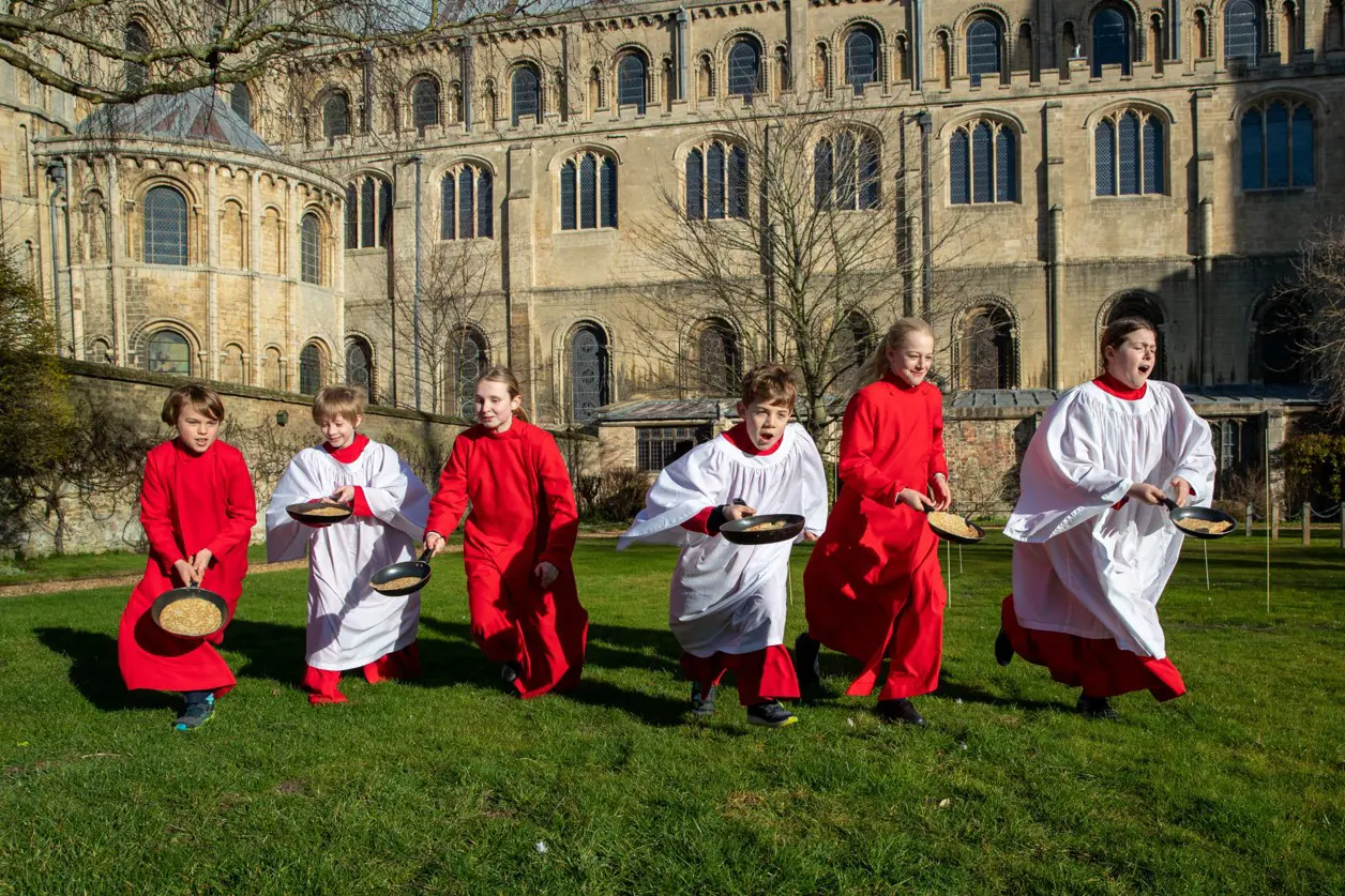 King's Ely Choristers taking part in annual Pancake Race outside Ely Cathedral 