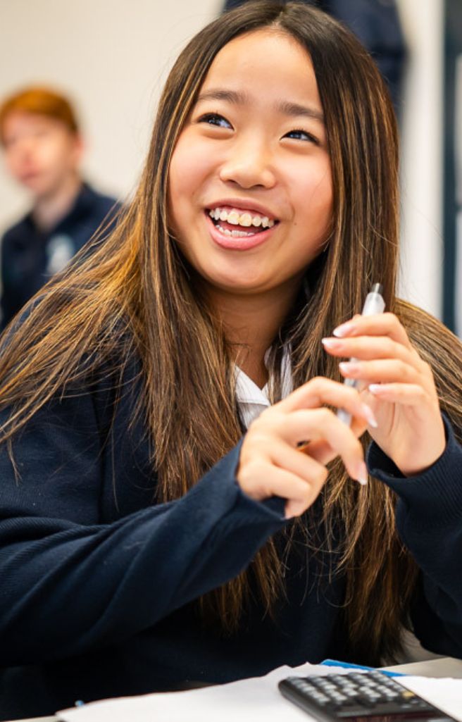 King's Ely International student laughing in classroom. King's Ely is a private boarding school in Cambridgeshire. 