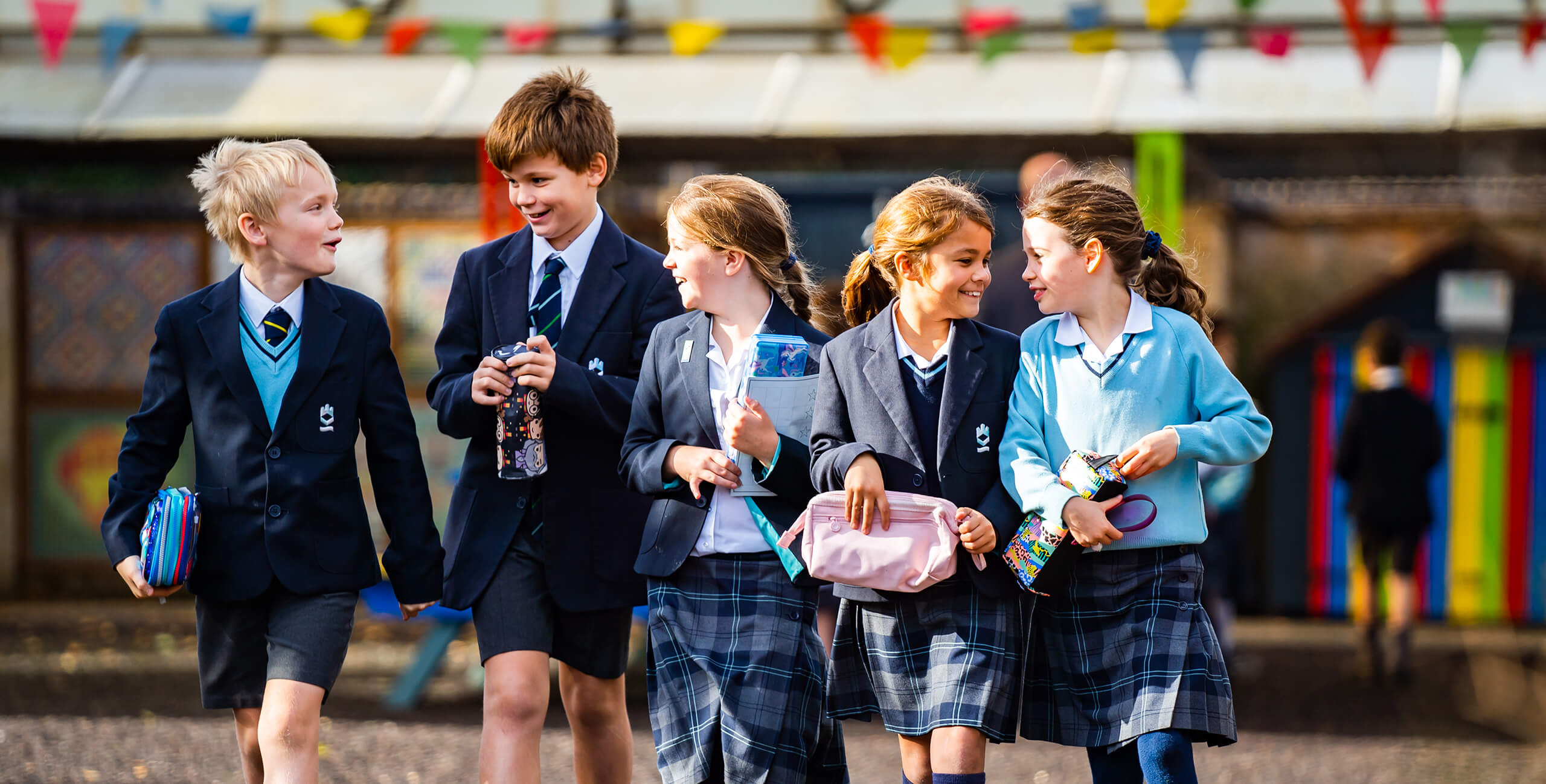 King's Ely Prep students walking outside and laughing together 