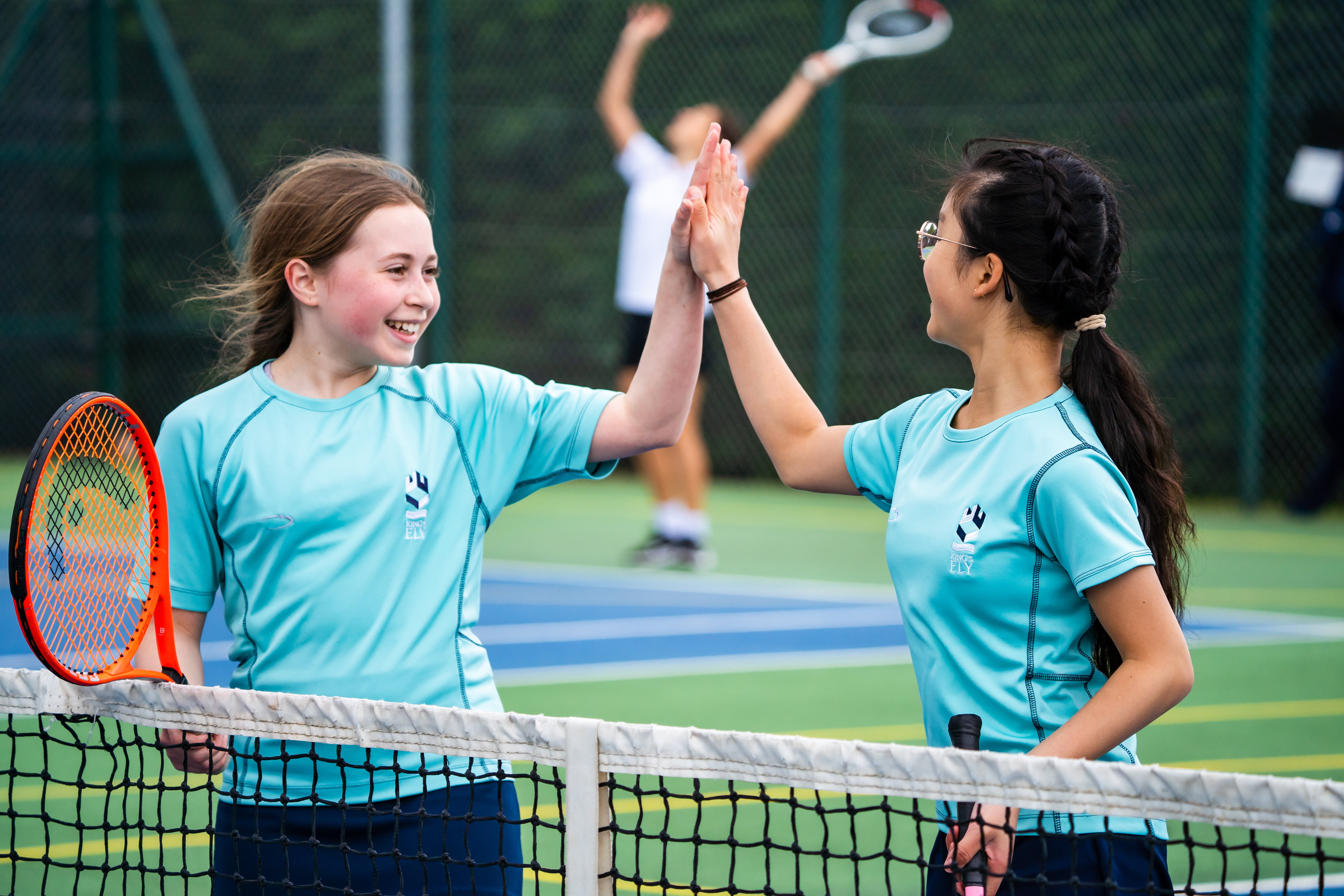 Two Prep School Students High Fiving during Tennis at King's Ely, a Private Day and Boarding School near Cambridge, in Ely.