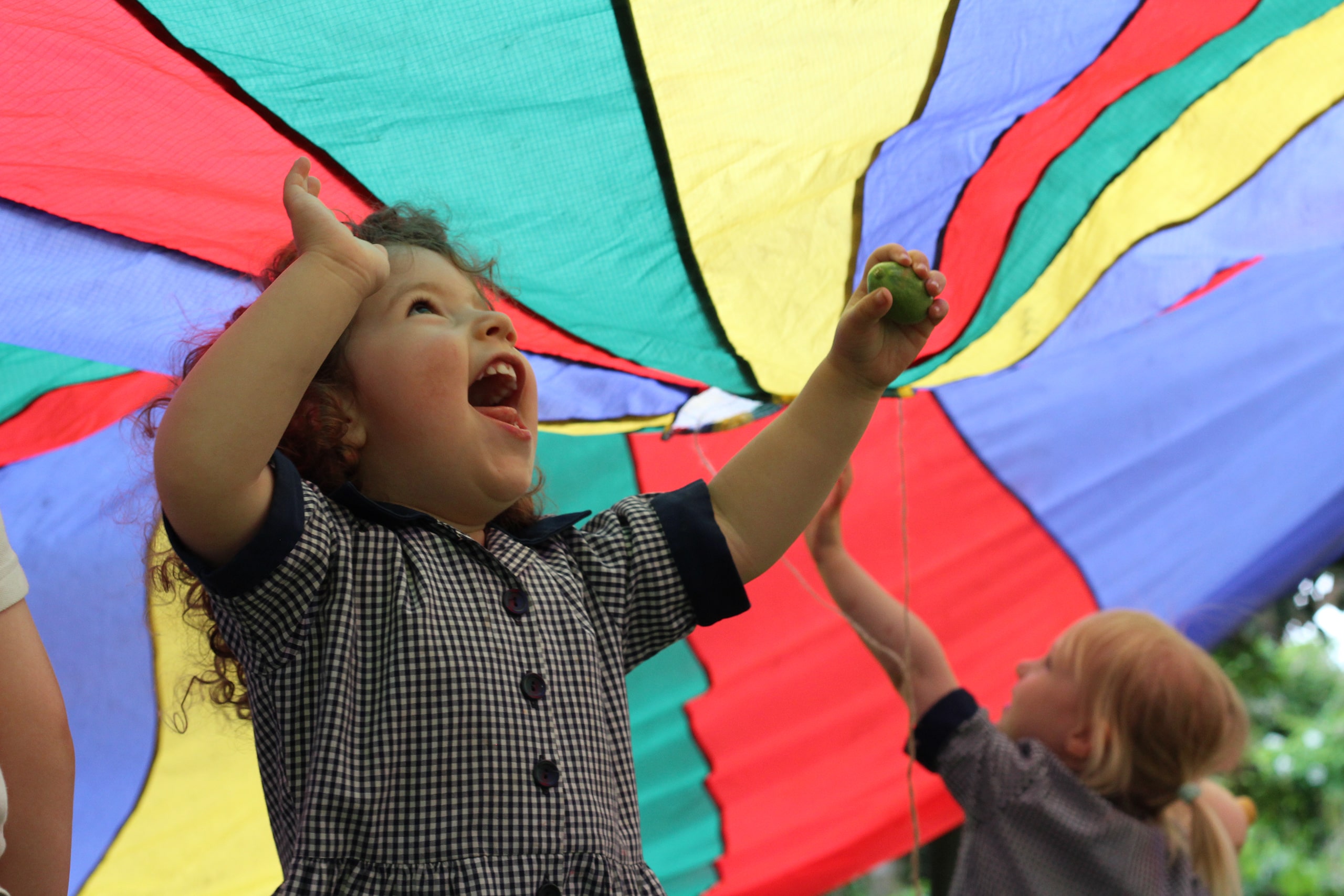 King's Ely Nursery playing outside with parachute