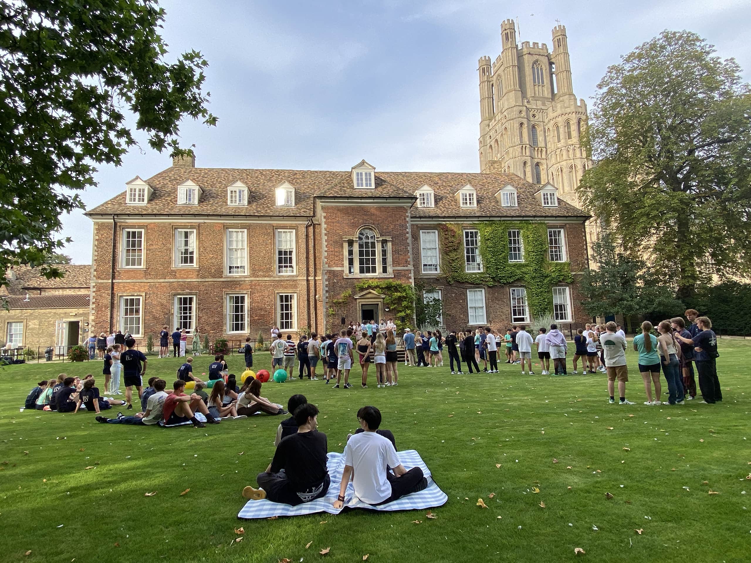 King's Ely Sixth Form students sitting outside The Old Palace. King's Ely Sixth Form is a private Sixth Form in Cambridgeshire. 